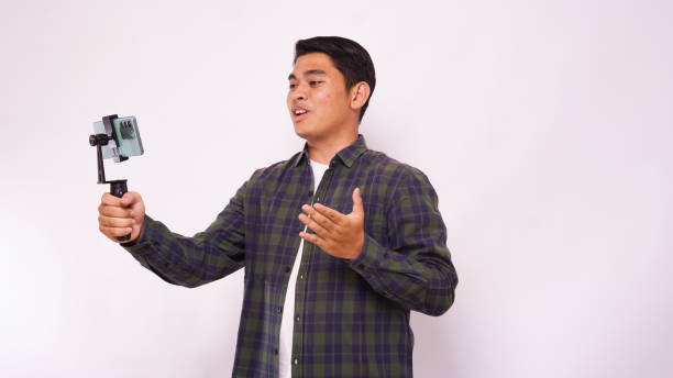 istock Asian man make a video blogging against white background 1944342291