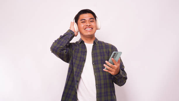 istock Asian man listening music on smartphone using headphone wireless 1944344399