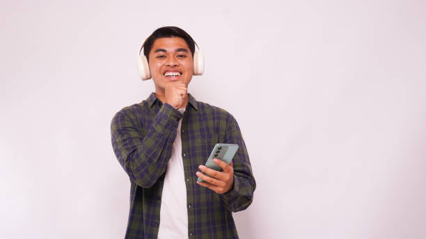 istock Asian man listening music on smartphone using headphone wireless 1944344922