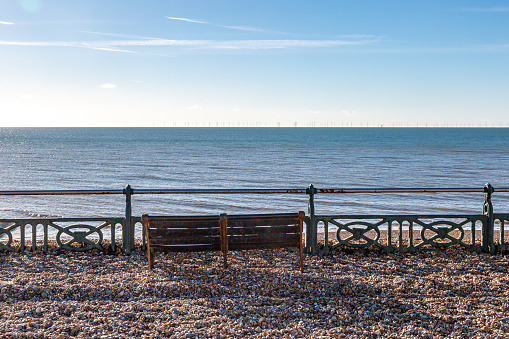 A view over the promenade at Brighton with pebbles washed up following a high tide