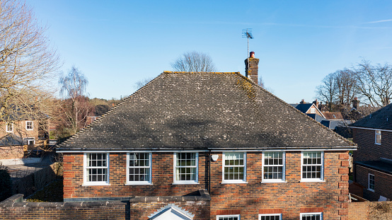 Aerial view of pitched tiled roof of detached house in West Sussex, UK