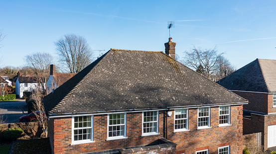 Aerial view of pitched tiled roof of detached house in England