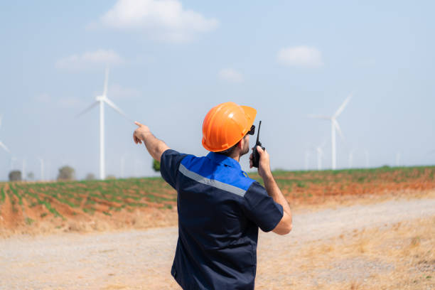 istock Engineer working in wind turbine farm with blue sky background 1944413431