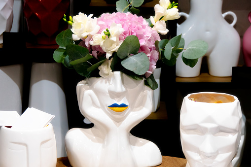 White flower vase in the shape of a woman's head in the cubist style
