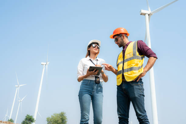 istock Engineer and architect discussing on wind turbine farm with blue sky background 1944416088