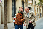 Playful gay male couple walking in urban area