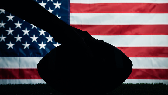 American football ball silhouette against the usa flag