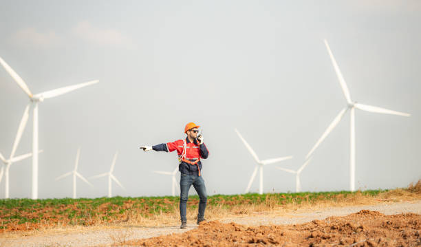 istock Engineer working in wind turbine farm with blue sky background 1944450088