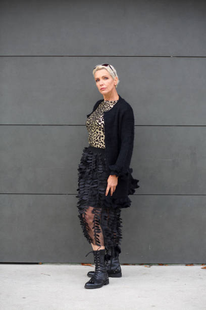 Fashionable mature woman portrait Mature woman standing at a gray wall. Senior female portrait. older woman purse stock pictures, royalty-free photos & images