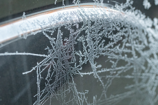 A criss cross patterns of ice crystals formed in the cold temperatures on a car window ice crystal formation unique