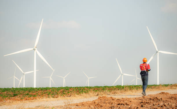 istock Engineer working in wind turbine farm with blue sky background 1944453822