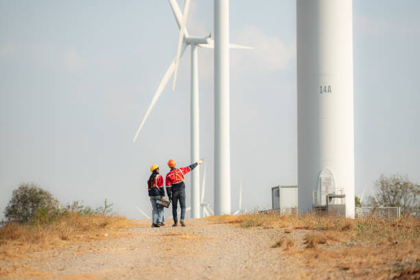 istock Engineer and technician discussing on the road with wind turbines in the background 1944457610