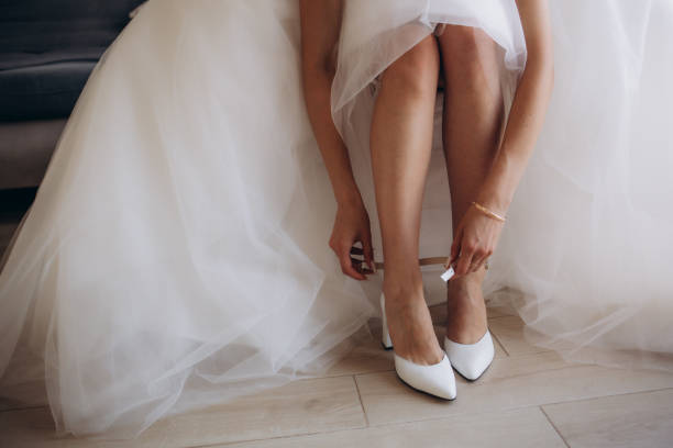 istock Bride puts on wedding shoes on her tender feet 1944471798