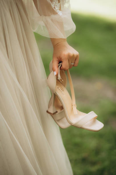 istock The bride on a walk holding shoes in her hands. 1944472835