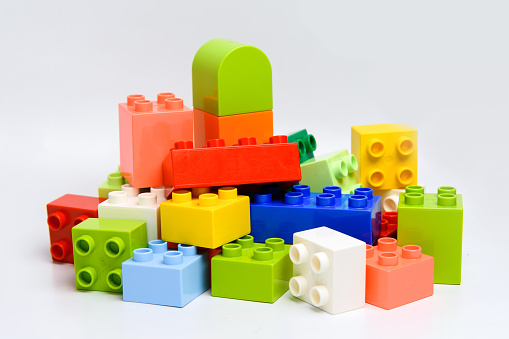 Parts of multicolored children's preschool toy constructor block heap. Pile creative block shape detail.