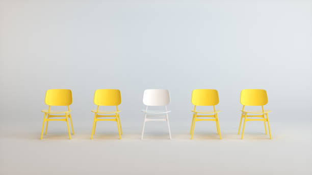 istock White Chair That Stands Out From the Yellow Chairs Crowd on a Soft White Studio Background. Business concept. Job Vacancy. 1944525173