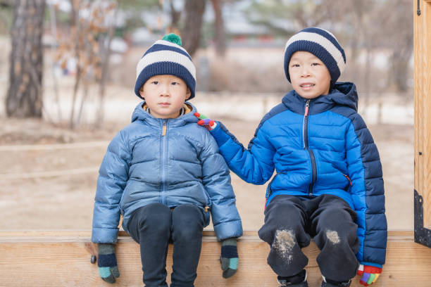 An adorable young child dressed warmly, happily experiencing a snowy winter day in an outdoor setting