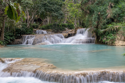 Kuang Si Waterfall in the morning at Luang prabang,Laos. Waterfalls from limestone mountains give the water a beautiful clear blue color.