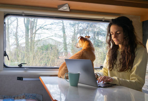 istock Woman working remotely from a motor home with her dog 1944546892