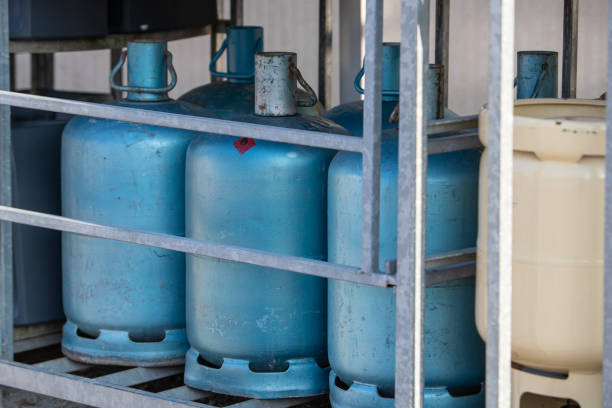 White gas bottle container in a store Set of several white gas bottles lying in an outdoor locker inflamable stock pictures, royalty-free photos & images