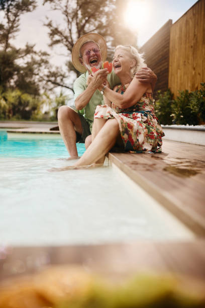 istock Cheerful senior couple eating watermelon by the pool. 1944565357