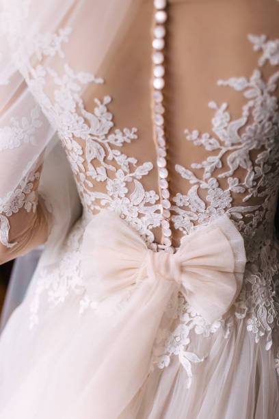 istock back view. Beautiful luxurious lace white dress with buttons and a nice big bow on the back. 1944571745