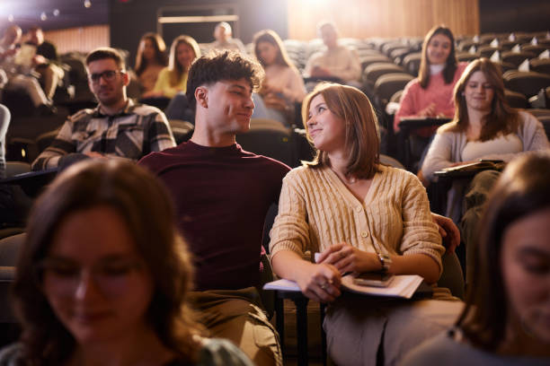istock Smiling college couple talking on a class at lecture hall. 1944599768