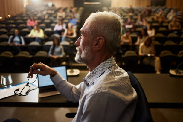 istock Thoughtful mature professor on a class at lecture hall. 1944603474