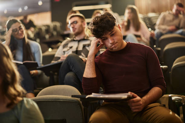 istock Worried college student reading a lecture on a class in amphitheater. 1944603997