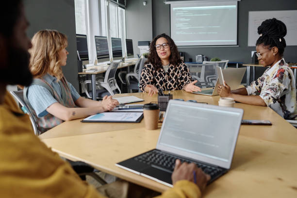 istock Young Colleagues Discussing IT Project Sitting at Table in Office 1944610843