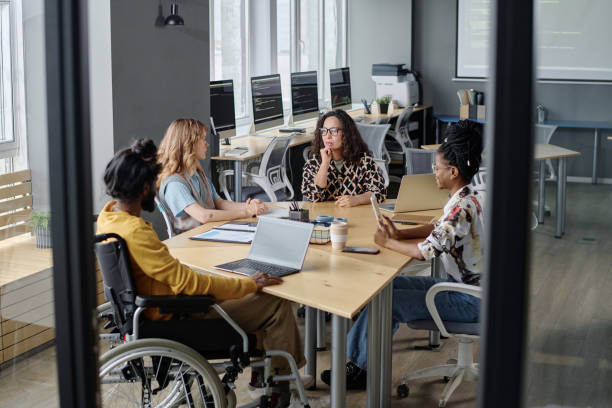 istock Diverse Programmers Discussing Business Affairs at Desk in Modern Urban Office 1944610972