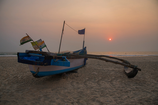 Fishing boat on the beach at sunset time, Goa, India, Asia. Background. Backdrop. Wallpaper.