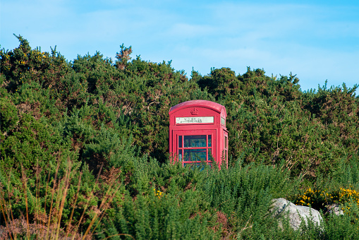 A red telephone kiosk on a frosty day in a remote location in the Highlands, Scotland