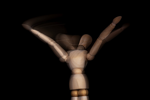 wooden mannequin in motion with hands up