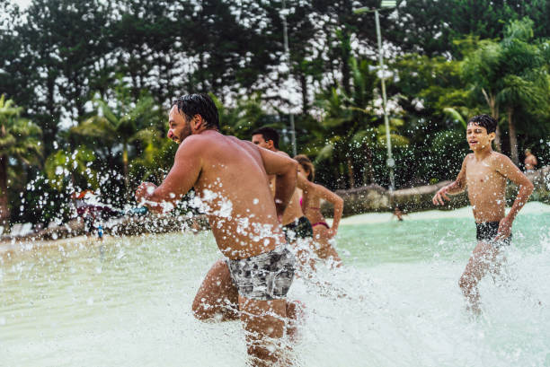 istock Happy family running at water park 1944642239
