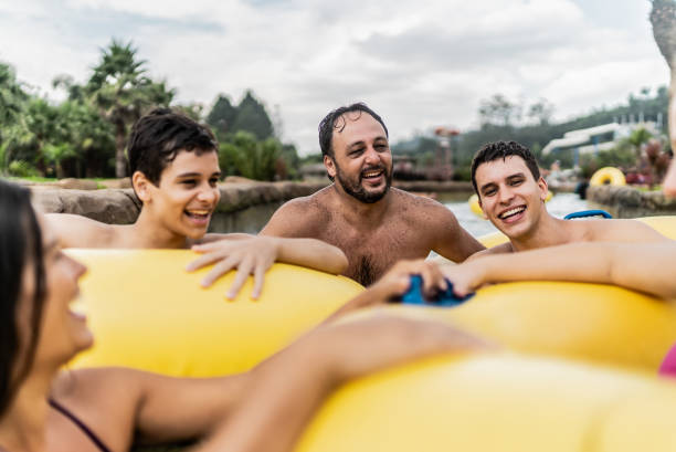 istock Family talking and floating on water at water park 1944649600