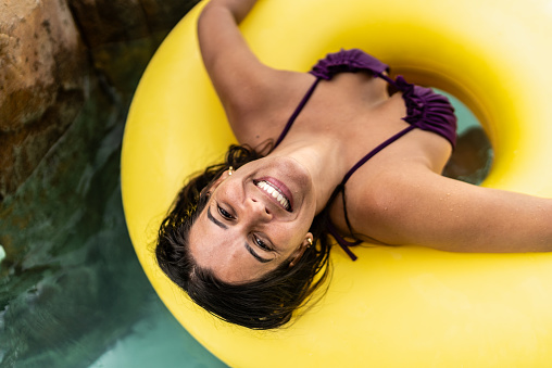 Portrait of a mature woman floating on water at water park