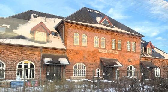 Nørresundby Station in Jutland was closed in 1972. This photograph captures the scene on January 12th, 2024, driving by the station by train on the way to Aalborg airport.