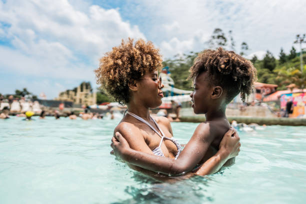 istock Mother talking with son at water park swimming pool 1944664281