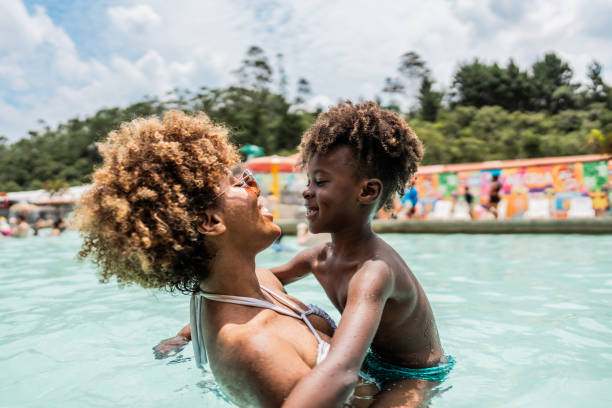 istock Mother playing with son at water park swimming pool 1944664822