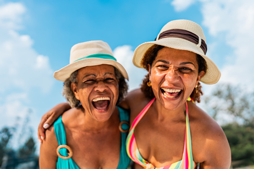Portrait of happy mother and daughter at the beach