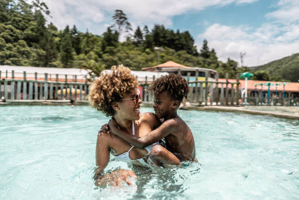 istock Mother talking with son at water park swimming pool 1944667963