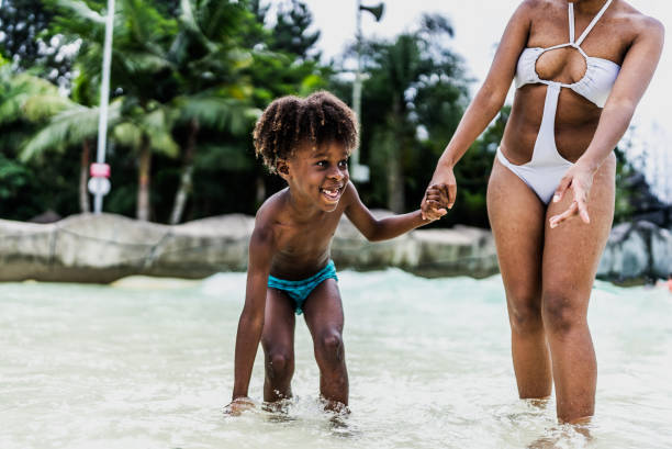 istock Mother and son playing at water park pool 1944675343