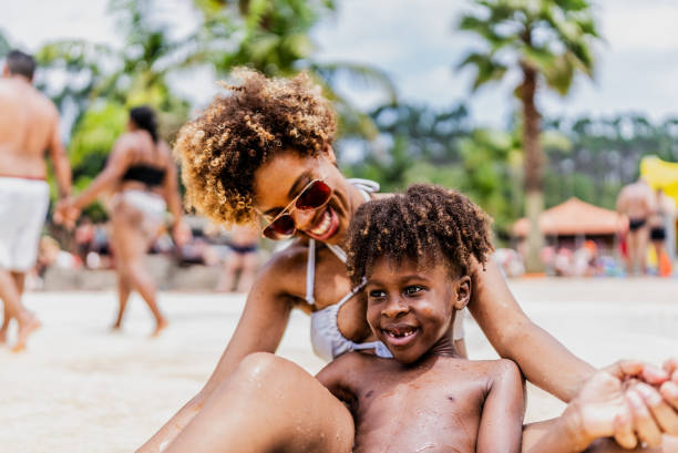 istock Mother and son playing at water park pool 1944675351