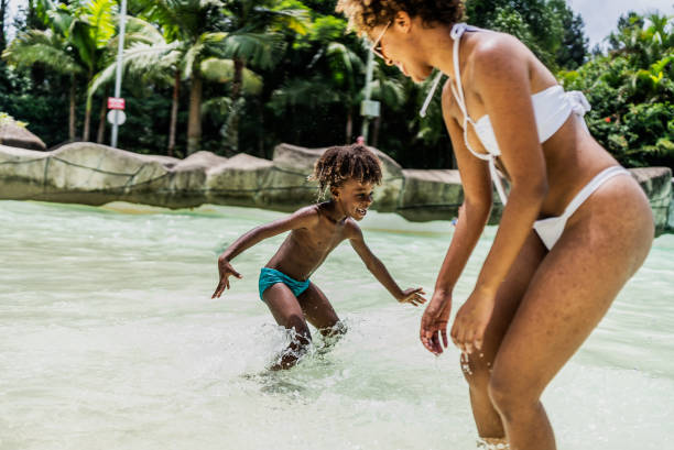 Mother and son playing at water park pool