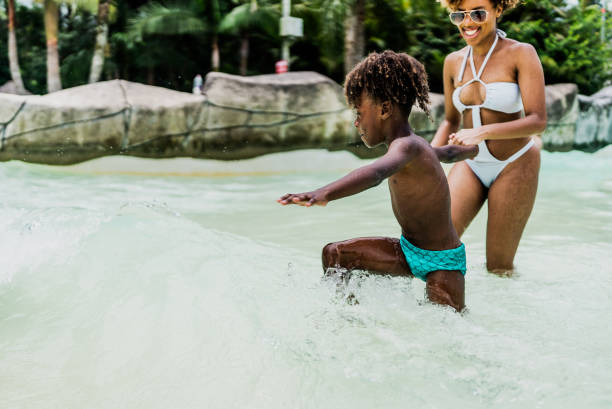 istock Mother and son playing at water park pool 1944675887