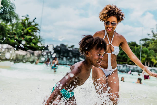 istock Mother and son playing at water park pool 1944675909