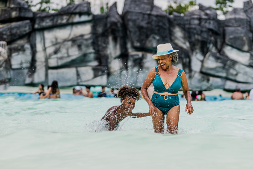 Grandmother and grandson playing at water park pool
