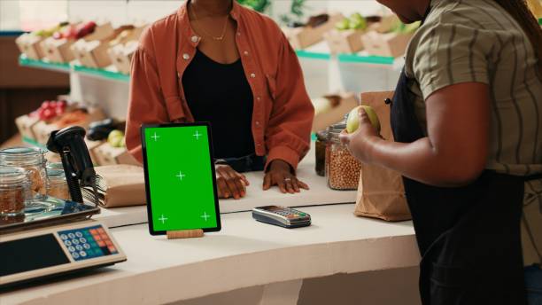 istock Tablet showing isolated greenscreen display at cash register 1944690408