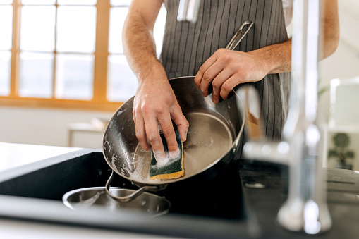 Close up shot of man washing cooking pan